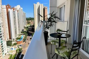Un balcón con mesa y sillas y vista a una ciudad. en Apto charmoso Gleba Palhano, en Londrina
