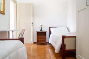 a bedroom with two beds and a dresser with a night stand at Padova Umberto center appartments in Padova
