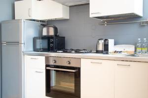 a kitchen with a stove and a microwave at Padova Umberto center appartments in Padova +125 photos