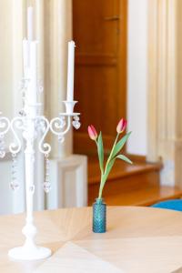 a vase with pink flowers sitting on a table at MB SUITES Margutta in Rome +23 photos