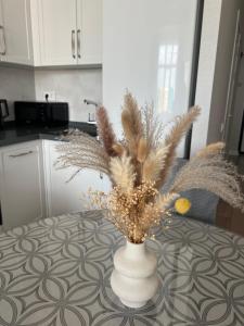 eine Vase mit Federn auf dem Tisch in der Küche in der Unterkunft Premium Plaza in Aqtau + 3 Fotos