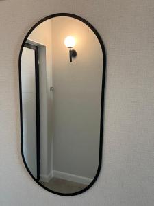 ein Spiegel, der mit einer Lampe an der Wand hängt in der Unterkunft Premium Plaza in Aqtau