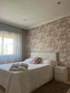 ポンテベドラにあるVilla Lila - planta 1ªの花柄の壁紙が貼られたベッドのある寝室