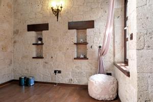 a room with a stone wall with a table and a stool at Mai Alaçatı in Cesme