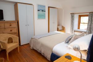 a bedroom with a bed and a desk and a dresser at Y Bwthyn Newport, Pembrokeshire in Newport Pembrokeshire