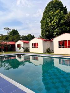 a swimming pool in front of two buildings at Cabañas el paraiso in Villavicencio