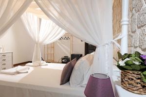 a bedroom with a white bed with a canopy at Mai Alaçatı in Cesme