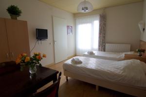 una camera d'albergo con due letti, un tavolo e una finestra di Stichting Veenloopcentrum Weiteveen a Weiteveen Altre 12 foto