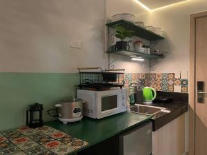 a kitchen with a microwave and a sink at Poolside Apartment - Sleeps 4 Ac & Hot Shower in Marilao