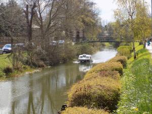 a boat traveling down a river with a bridge at River Lodge B&B Ltd in Spalding