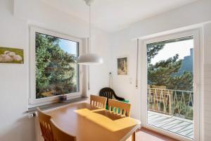 ein Esszimmer mit einem Tisch und einem großen Fenster in der Unterkunft Ferienwohnung Rheinblick in Sankt Goar