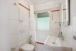 ein weißes Badezimmer mit Waschbecken und Toilette in der Unterkunft Ferienwohnung Rheinblick in Sankt Goar + 19 Fotos