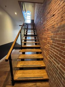 een trap met een bakstenen muur en houten trappen bij Spacious King Room at The Franklin Hotel Downtown in St. John's