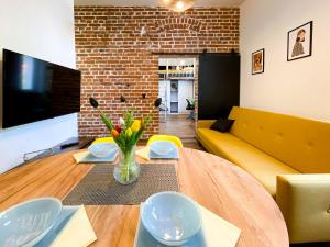 a living room with a wooden table and a yellow couch at 35-Sailoft - DeerRest Apart in Jelenia Góra