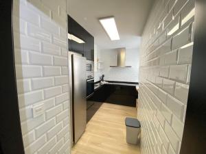 a hallway leading to a kitchen with white brick walls at Apartmento Carmen Viejo, Centro in Sanlúcar de Barrameda +20 photos