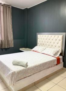 a bed in a bedroom with a blue wall at Hostal Skyblue in Asia