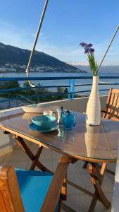 un tavolo in legno con un vaso in cima a un balcone di Endless Summer a Vlorë