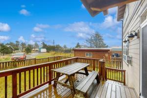 a wooden deck with a picnic table on it at Cape Kiwanda Hideaway in Pacific City