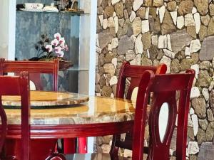 tavolo da pranzo con sedie e parete in pietra di Extra Big Unit with Paddy Field View and 5 mins to Sekinchan attractions a Sekincan
