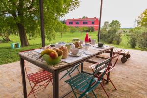 a wooden table with a bowl of fruit on it at all'ombra del Bagolaro in Taglio di Po