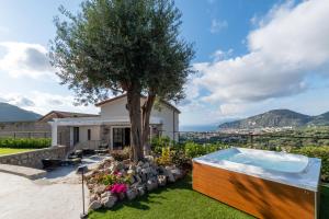 a garden with a tree and a hot tub at Sorrento-luxury Suites in Colli di Fontanelle
