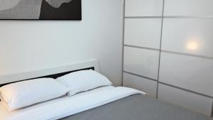 a bedroom with white walls and a bed with white pillows at Apartment Sarah in Čavle +20 photos