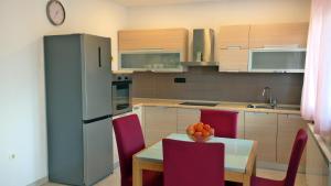 a kitchen with a table and chairs and a refrigerator at Apartment Sarah in Čavle