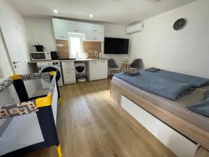 a bedroom with a large bed and a kitchen at Apartment house close to Bojnice in Prievidza