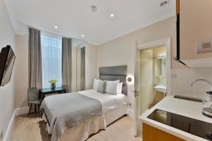 a hotel room with a bed and a sink at Cleveland Residences Kensington in London