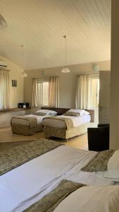 a bedroom with two beds and a room with windows at Paraty Bungalows Bar E Hotel in Paraty