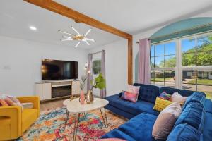 sala de estar con sofás azules y TV en 5BD,2BA Cheerful Retreat with Backyard, en Dallas