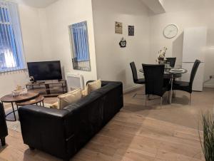 ニューカッスル・アポン・タインにある3 Bed Executive Apartmentの黒いソファとテーブルのあるリビングルーム
