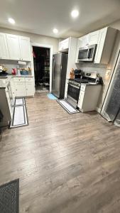a kitchen with stainless steel appliances and wooden floors at Rooms available in a single Family home shared with Host in Willingboro