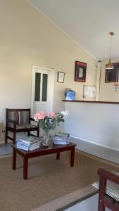 a living room with a vase of flowers on a table at Paraty Bungalows Bar E Hotel in Paraty