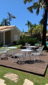 a group of white chairs and tables on a deck at Paraty Bungalows Bar E Hotel in Paraty