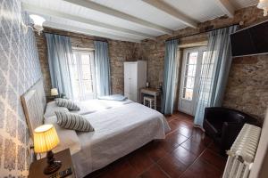 ein Schlafzimmer mit einem großen Bett und zwei Fenstern in der Unterkunft Hotel Puerto Arnela in Camariñas