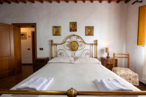 a bedroom with a large bed with white sheets at Tipica casa nelle Crete Senesi in Monteroni dʼArbia