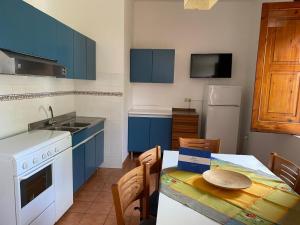 eine Küche mit blauen Schränken und einem Tisch mit einem Tisch in der Unterkunft Le Rose in Marina di Camerota + 44 Fotos