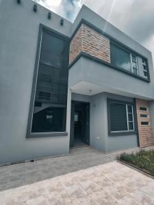 ein modernes Haus mit einem großen Fenster in der Unterkunft Hermosa Casa Vacacional o de Hospedaje en Cuenca in Cuenca