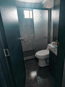 ein Badezimmer mit Toilette und Waschbecken in der Unterkunft Hermosa Casa Vacacional o de Hospedaje en Cuenca in Cuenca + 3 Fotos