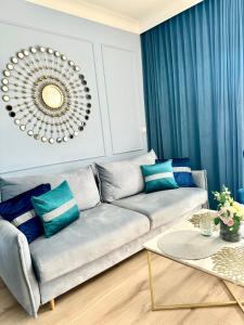 un salon avec un canapé et un miroir dans l'établissement Rezydencja Niechorze 108 Prestige by The Beach z Basenem i SPA, à Niechorze