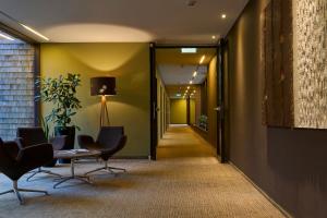 a hallway with chairs and a table and a lamp at Sternen Hotel Wolfurt in Bregenz