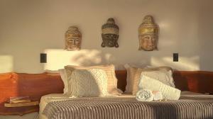 a bedroom with a bed with masks on the wall at Pipa Sunset Villa in Pipa