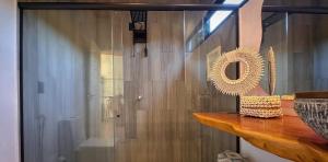 a bathroom with a mirror and a wooden wall at Pipa Sunset Villa in Pipa