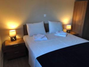 Un dormitorio con una cama grande con dos lámparas encima. en Cozy and modern house 350m to the see in Nikiti!, en Nikiti
