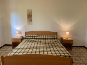 ein Schlafzimmer mit einem Bett und zwei Nachttischen mit Lampen in der Unterkunft Le Rose in Marina di Camerota