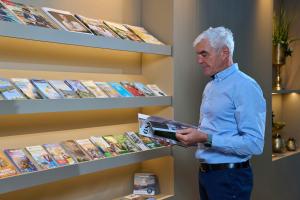 a man standing in a store looking at a book shelf at Sternen Hotel Wolfurt in Bregenz