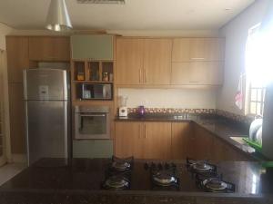 a kitchen with wooden cabinets and a stove top oven at A Casa à Beira do Lago Bortolan in Poços de Caldas