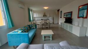Una sala de estar con un sofá azul y una mesa. en Casa al Castello fra Mare e Storia, en Ameglia