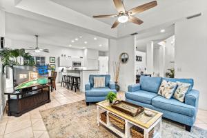 a living room with two blue couches and a tv at Villa Champagne - 5322 in Siesta Key